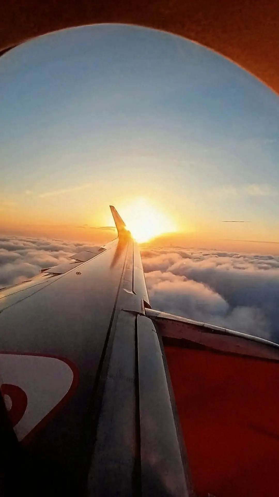Sunset over the clouds from an airplane window